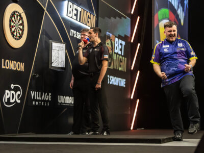 Luke Littler celebrates hitting the winning dart on stage in the 2024 BetMGM Premier League Darts