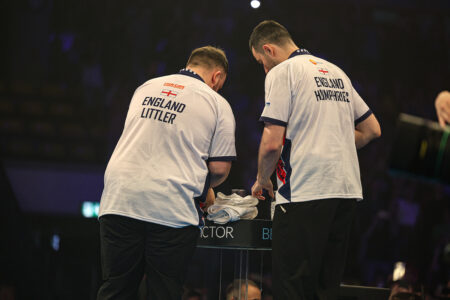 Luke Humphries and Luke Littler of Team England competing together in their matching white and navy national shirts on stage during the pairs match at the World Cup of Darts in Frankfurt.