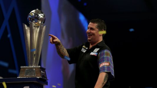 Gary Anderson next to the Sid Waddell Trophy, awarded to the winner of the World Darts Championship.