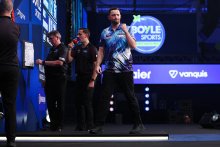 Luke Humphries celebrates on stage during the 2026 World Grand Prix.